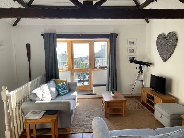 View from the kitchen across the living room and out to the balcony at Banjo Cottage