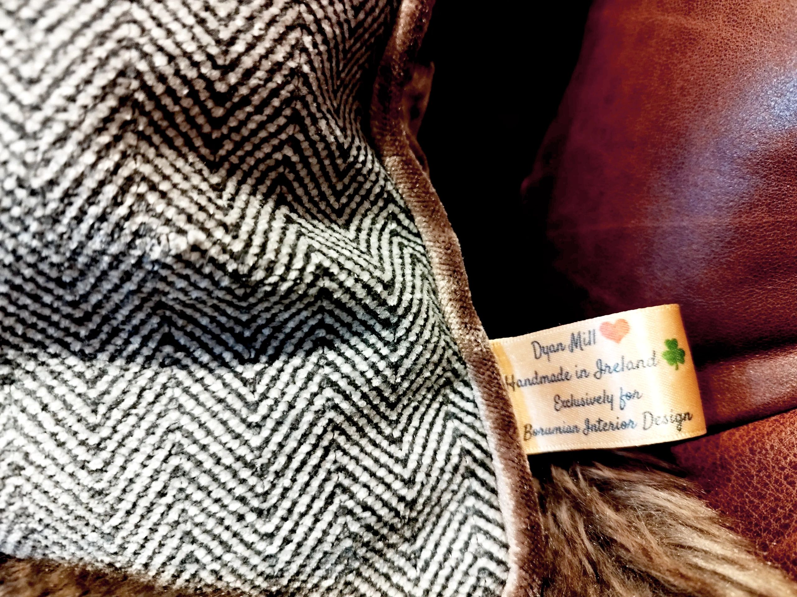 Close-up of a fabric label on a textured textile and leather background.