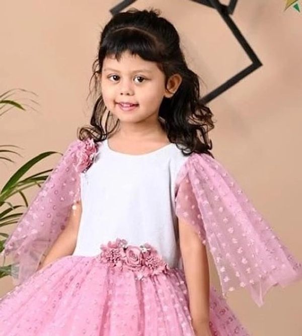 Young girl in a pink and white dress with floral accents.