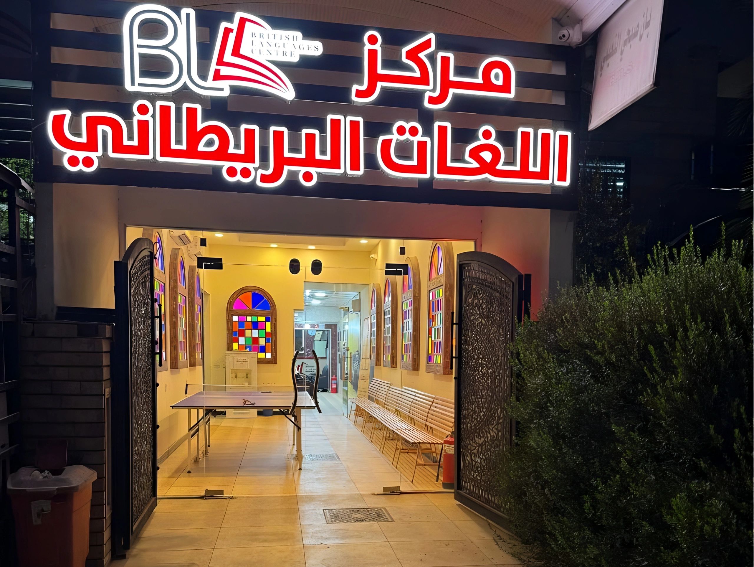 Entrance of British Languages Centre with neon sign at night.