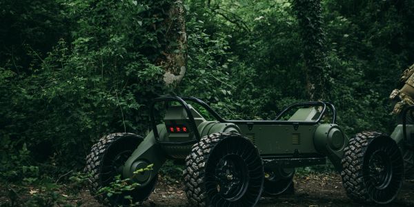 A rugged, futuristic off-road vehicle in a dense forest.