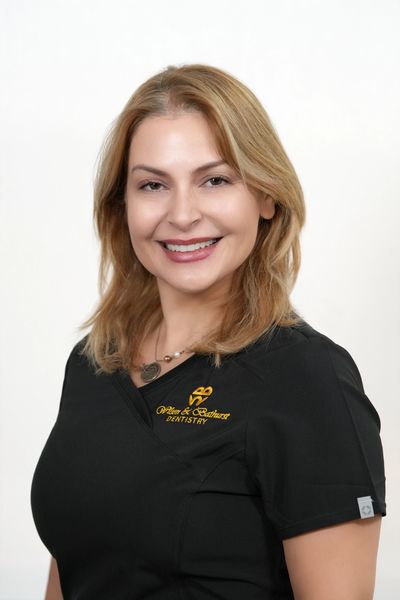 Smiling female dentist in black uniform with logo on white background.
