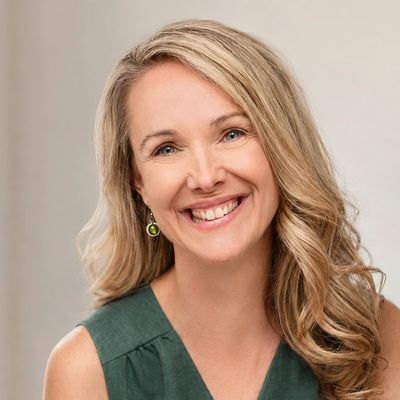 Portrait d'une femme souriante aux cheveux blonds.
