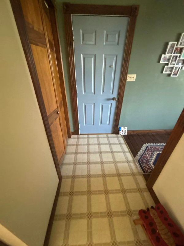 A hallway with a blue door and wooden trims.