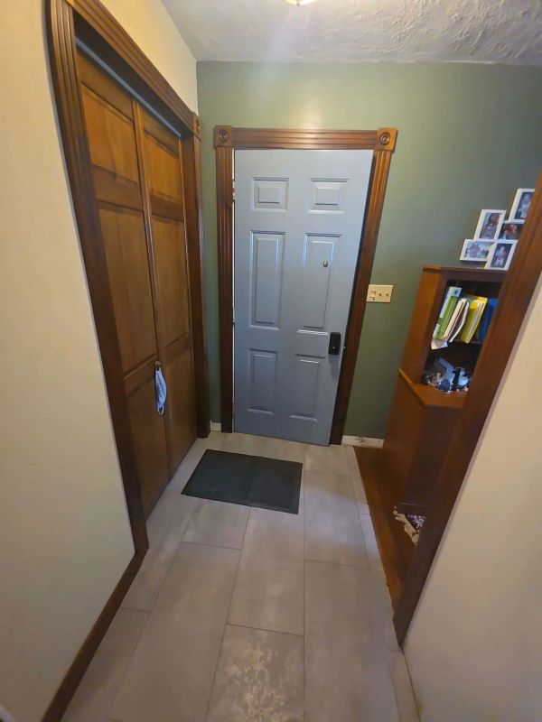 Entryway with blue door, wooden closets, and bookshelf.