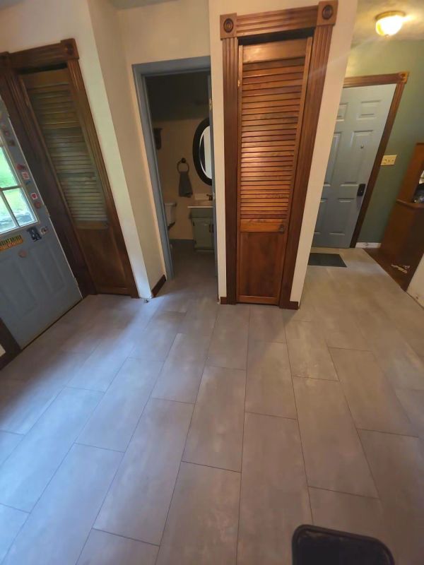 Hallway with wooden closet doors and tiled floor.
