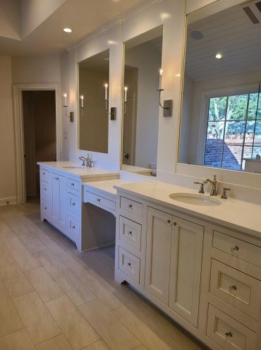 Modern bathroom with double sinks and large mirrors.