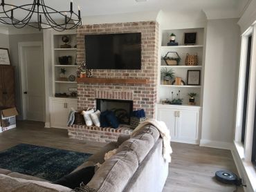 Cozy living room with brick fireplace and wall-mounted TV.