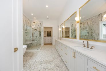Modern bathroom with double vanity and glass shower.