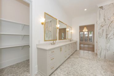 Elegant bathroom with marble flooring and dual mirrors.