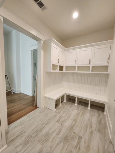 Modern white storage bench with cabinets.