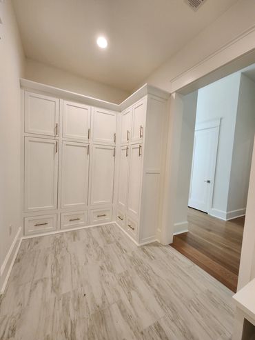 Bright white built-in cabinets in a spacious room.