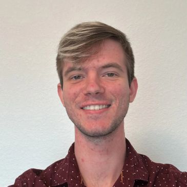 Young man smiling in a casual shirt.