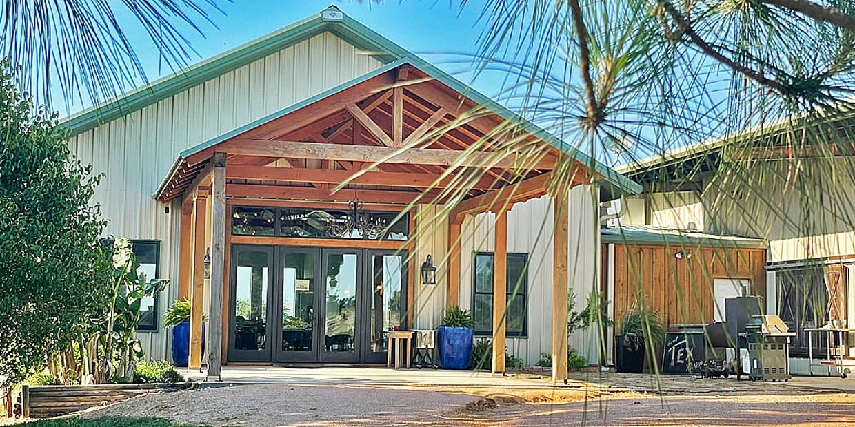Modern barn-style building with wooden beams and glass doors.