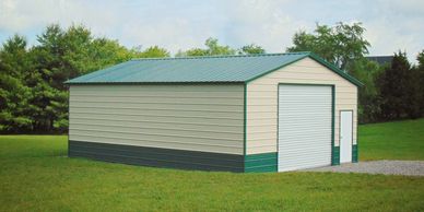 Metal storage building with a roll-up door and side entry door on a grassy lawn.