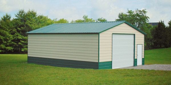 Metal storage building with a roll-up door and side entry door on a grassy lawn.