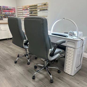 Modern nail salon setup with two chairs and a manicure station.