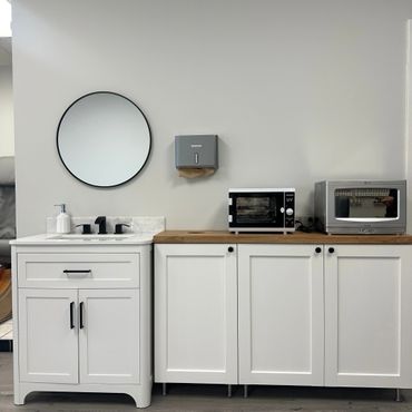 Clean, modern sink area with white cabinets and sterilizing equipment.