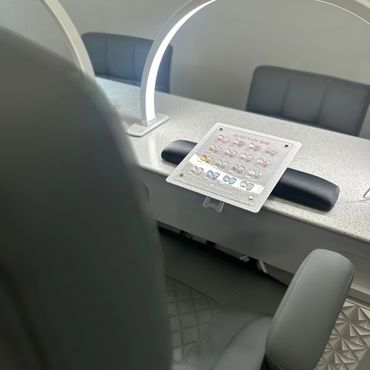 A stylish nail salon station with color samples and comfortable chairs.