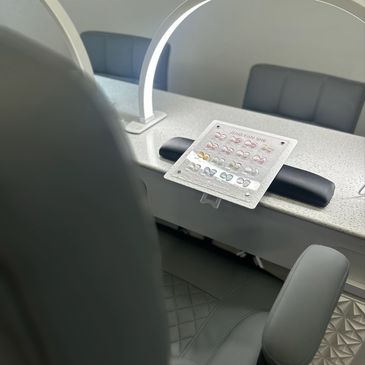 A nail salon station with color samples and a chair.