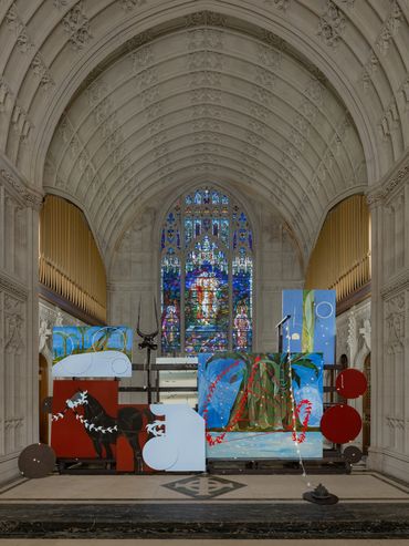 Instalación de arte moderno en interior de iglesia con vitrales.