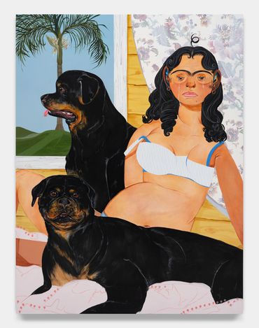 Mujer con dos perros rottweiler en un interior.