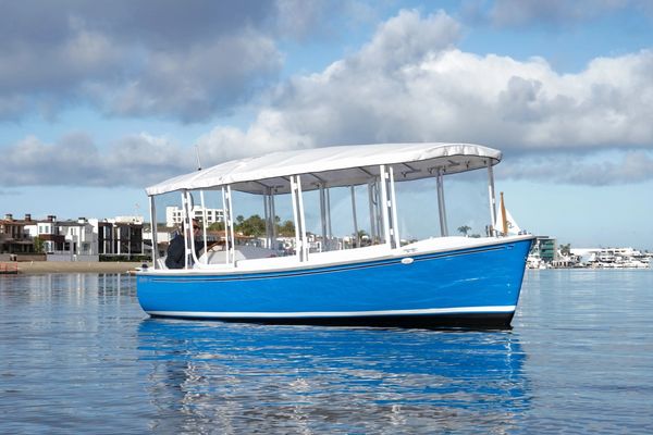 Blue boat with white canopy on calm water.