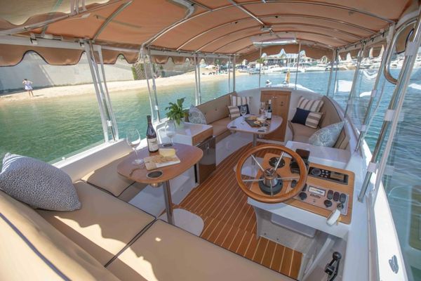 Cozy boat interior with seating and drinks.