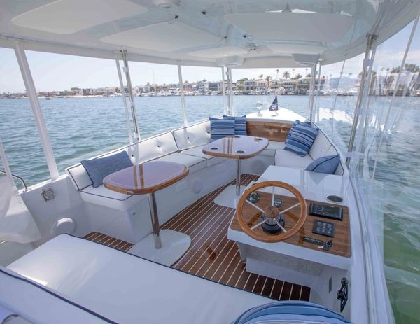 Spacious and elegant boat interior with seating and controls.