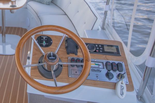 Wooden steering wheel on a boat dashboard.