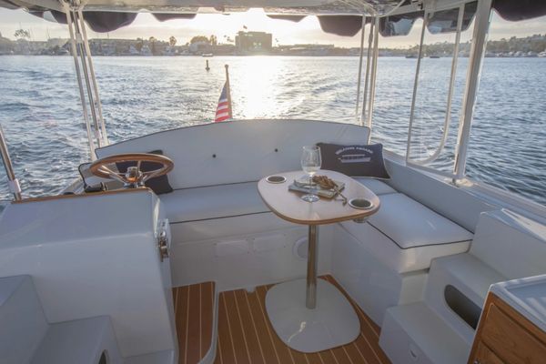 Seating area on a boat with a table and wine glass.