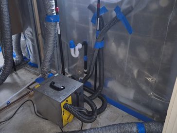 Industrial air ventilation or filtration unit with ducting in a construction or renovation site.