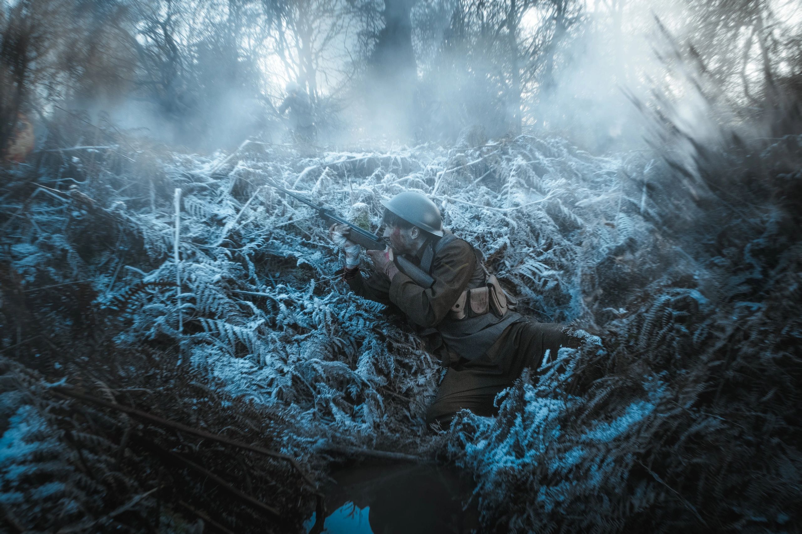 Soldier aiming rifle in a foggy forest trench.