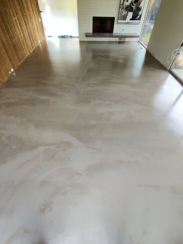 Spacious room with polished concrete floor and fireplace.