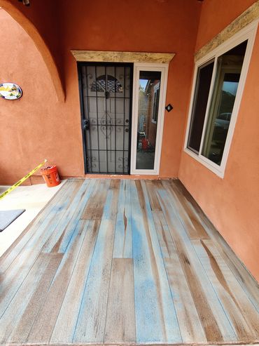 A porch with unique blue and brown wood-patterned flooring and terracotta-colored walls.