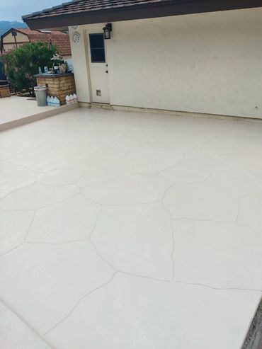 Outdoor concrete patio with visible cracks in a residential backyard.