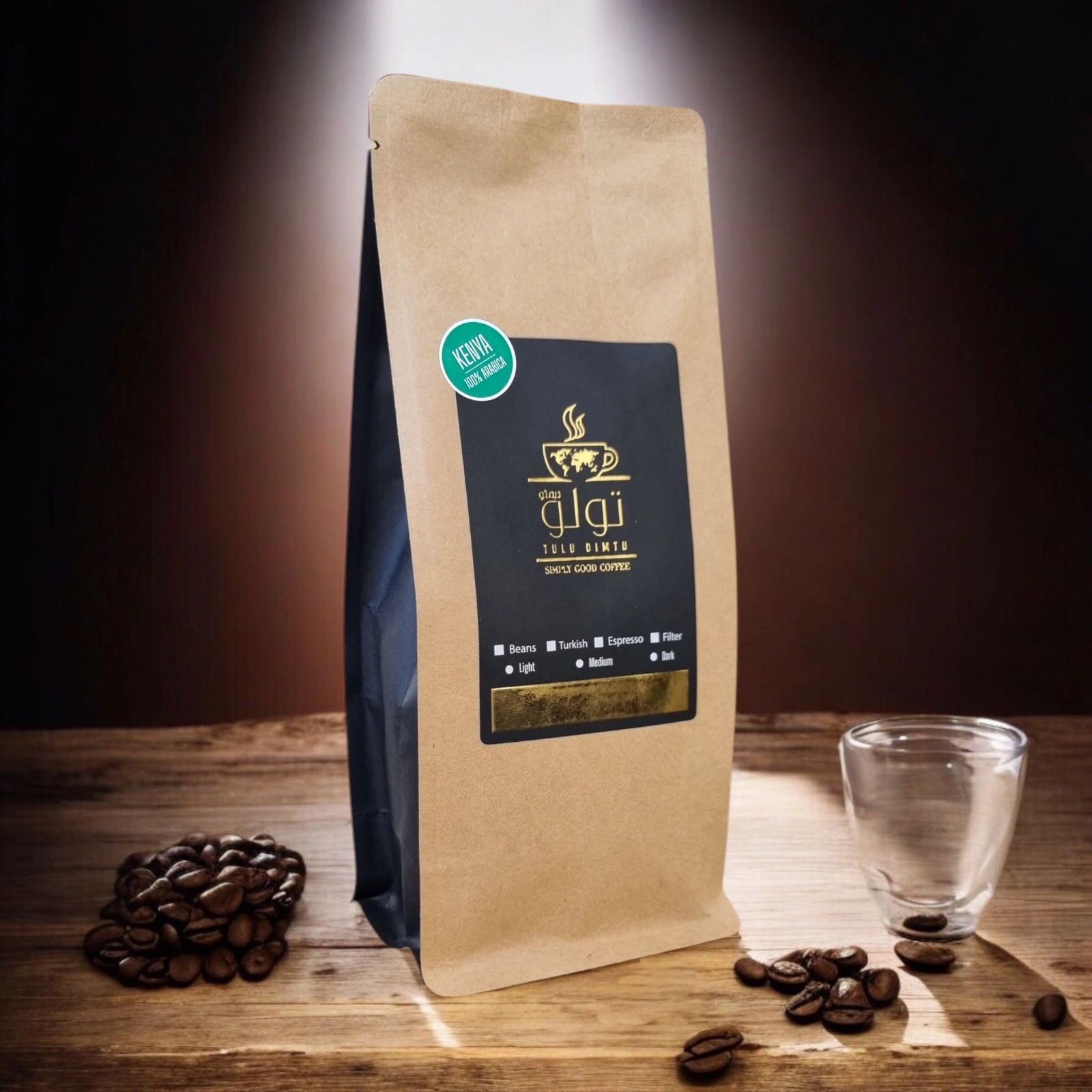 Brown coffee bag labeled Tulu Dimtu with coffee beans and a glass cup.