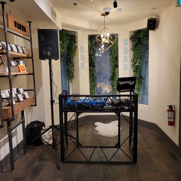 Minimalist DJ setup with geometric lighting and greenery in a cozy corner.