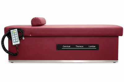 Red therapy table with control panel and cushion.