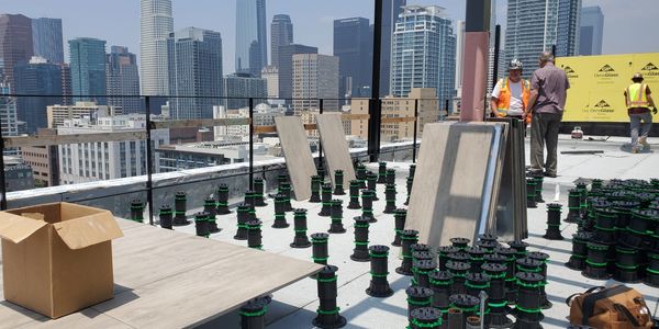 Construction site on rooftop with city skyline.