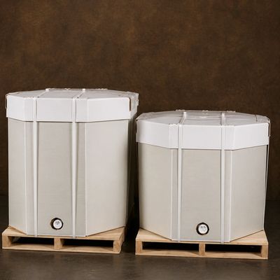 Two large white containers on wooden pallets against a brown background.