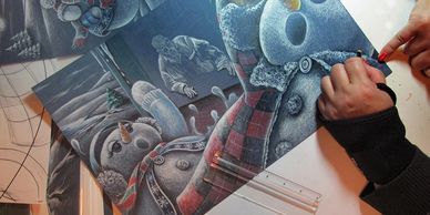 Artist coloring a detailed snowman winter scene drawing.