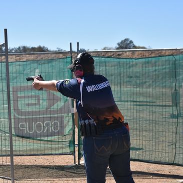 Shooter engaging paper targets in an IPSC course