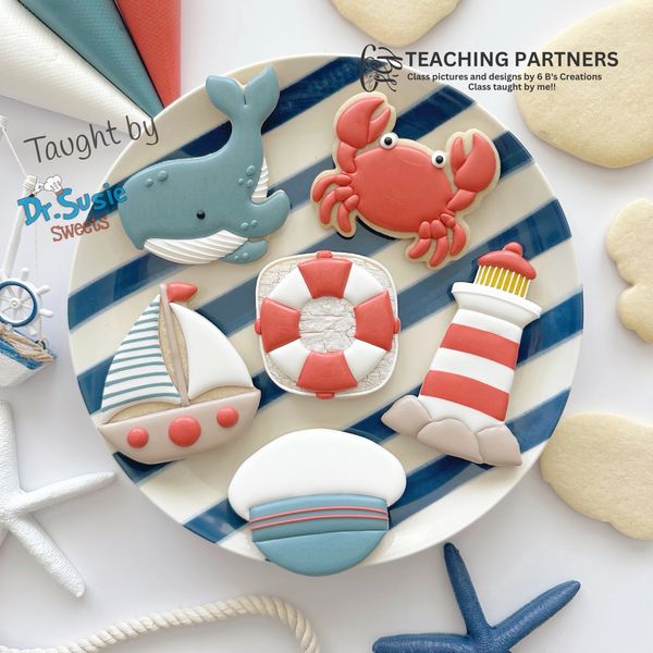 Nautical-themed decorated cookies on a striped plate with ocean elements.