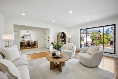 Bright, modern living room with comfy chairs and large window.