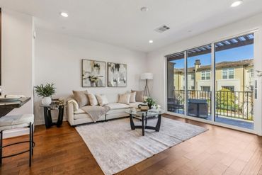 Modern living room with beige sofa and large sliding glass doors.