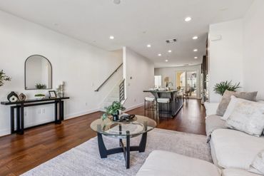 Bright modern living room with white walls and wooden floors.