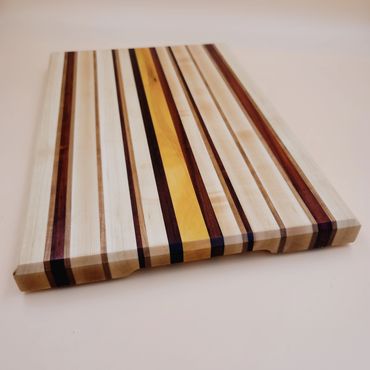 Unique cutting board featuring Yellow Heart, Padauk, Hard Maple and Cherry Wood