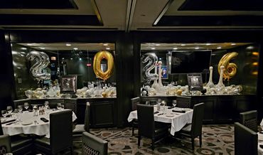 Elegant New Year's Eve dining setup with balloons and festive decorations.