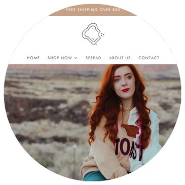 Red-haired woman wearing a Toast hoodie outdoors.